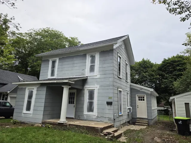Two-story home with light gray siding, white trim and a white porch column