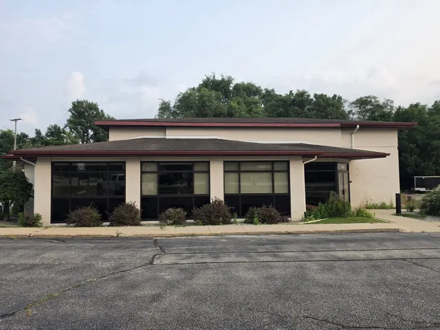 Single-story commercial building with a tan exterior and a flat roofline